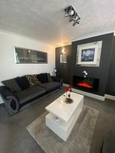 a living room with a couch and a fireplace at The Brook House - Spacious 3 Bed Home From Home in Burton upon Trent
