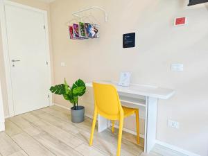 a dining room with a yellow chair and a table at YR Apartments Milan - Bocconi - Fashion Apartment in Milan
