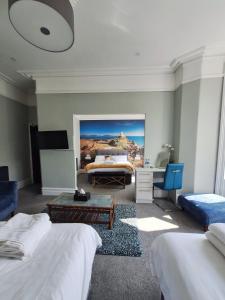 1 dormitorio con 2 camas, escritorio y TV en No 27 Chapel Street Guest House en Llandudno