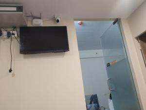a room with a shower and a laptop on the wall at Hotel Nova Atlanta Shopping Mall in Surat +10 photos