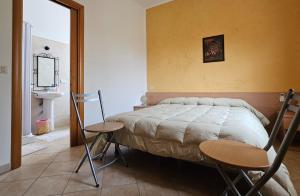 1 dormitorio con 1 cama, 2 sillas y lavamanos en Bed & Breakfast Primavera, en Canosa Sannita