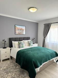 a bedroom with a large bed with a green blanket at Princess Retreat Beautiful Modern Aprt 2 min walk from Quarteira Beach in Quarteira