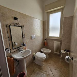 W łazience znajduje się umywalka, toaleta i lustro. w obiekcie Bed & Breakfast Primavera w mieście Canosa Sannita
