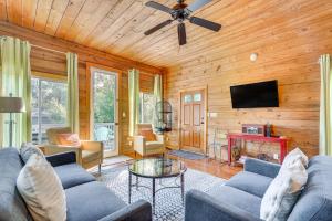 Una sala de estar con un sofá azul y un televisor. en The Bird House Lush Bungalow, Steps from Ocean!, en Folly Beach