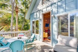 Un patio con una mesa y sillas en un porche. en The Bird House Lush Bungalow, Steps from Ocean!, en Folly Beach