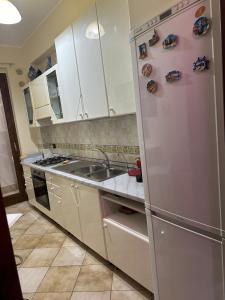 a kitchen with white cabinets and a stainless steel refrigerator at Casa d amare in Gioiosa Marea