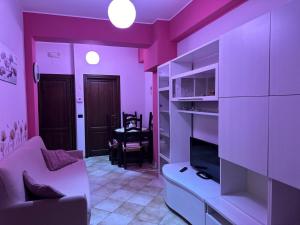 a purple living room with a couch and a tv at Casa d amare in Gioiosa Marea