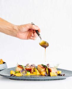 a person holding a spoon over a plate of food at Exclusive Boutique Hotel Elisabetta in Ronco sopra Ascona