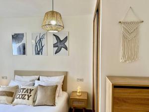 a bedroom with a bed with pillows and a chandelier at Sea Sound in Murcia