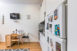 a kitchen with a refrigerator with pictures on the wall at GuestReady - Bella's Downtown Apartment in Porto