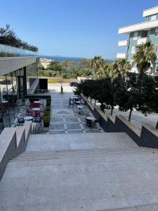 a courtyard with benches and tables and a building at BlueCoast Apartment Vlore in Vlorë