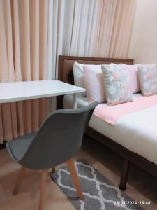 Locsin的住宿－Casita de Reina Staycation House - A cozy 1-Bedroom condo-style house，客房设有一张带桌子和椅子的床。