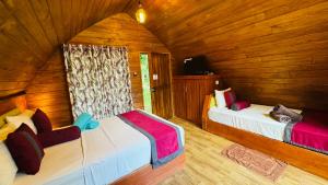 錫吉里亞的住宿－Palmyra Nature Resort Sigiriya，一间带两张床铺的卧室,位于带木墙的房间内