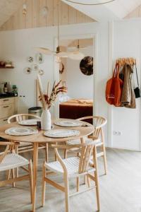 a dining room with a table and chairs and a kitchen at Hjort I Tiny House in Epe