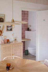 a kitchen with a table and a toilet in a room at Hjort I Tiny House in Epe