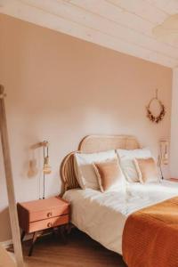 una camera da letto con letto, lenzuola e cuscini bianchi di Hjort I Tiny House a Epe