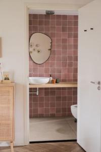La salle de bains est pourvue d'un lavabo et d'un miroir mural. dans l'établissement Hjort I Tiny House, à Epe