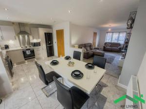cocina y sala de estar con mesa y sillas en Bright Bedroom in Modern House, en New Waltham