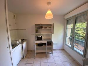 eine Küche mit einer Spüle und einer Mikrowelle in der Unterkunft Appartement moderne avec parking in Blois