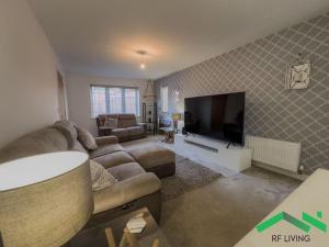 sala de estar con sofá y TV de pantalla plana en Bright Bedroom in Modern House, en New Waltham