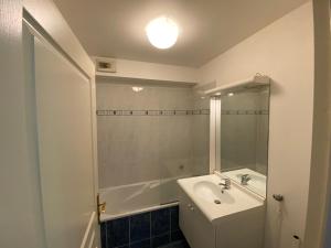 ein Badezimmer mit einem Waschbecken, einer Badewanne und einem Spiegel in der Unterkunft Appartement moderne avec parking in Blois