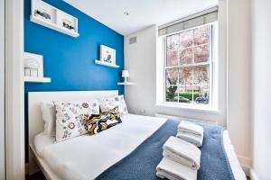 una camera da letto con pareti blu e un letto con cuscini di GuestReady - Classy haven near Camden Town a Londra