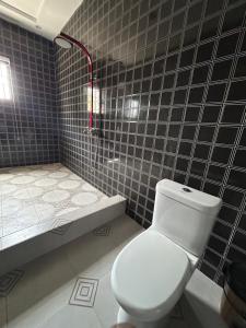 Regitton Hotel في Denu: حمام مع مرحاض ودش وحوض استحمام