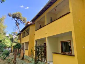 un edificio amarillo con una ventana en el lateral en Pousada Casinha Velha, en Macacos