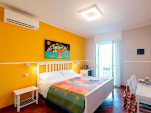 a bedroom with a bed and a yellow wall at ARIA DI MARE, Manarola - Camere con vista mare! in Manarola