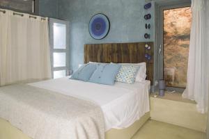 ein Schlafzimmer mit einem Bett mit blauen Kissen und einem Fenster in der Unterkunft Villa Platino in Torre Vado