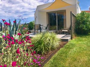 Casa pequeña con jardín con flores rosas en Villa Pignada, en Lanton