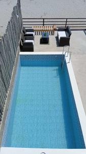 a blue swimming pool with two lounge chairs at BUNGALOWS CASAMAR in Tumbes