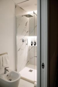 a white bathroom with a shower and a sink at ADOUNIA HOME in Naples +2 photos