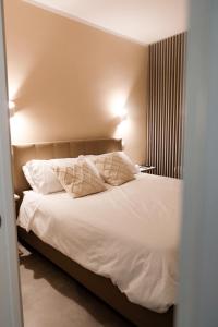 a bedroom with a bed with white sheets and pillows at ADOUNIA HOME in Naples