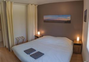 a bedroom with a white bed with two towels on it at 3 bedrooms, very quiet, fully equiped, between Bordeaux and Saint-Emilion in Vayres