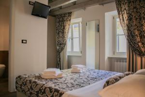 een slaapkamer met een bed met handdoeken erop bij Barbacan Boutique Hotel in Trieste