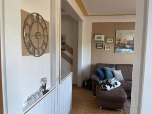 a living room with a couch and a clock on the wall at Seewohnung Zentral in Millstatt