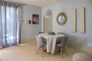 ein Esszimmer mit einem Tisch mit Stühlen und einem Spiegel in der Unterkunft Villa Platino in Torre Vado