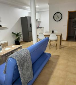 a living room with a blue couch and a table at Alforra Residence-T2 completo no Centro in Câmara de Lobos