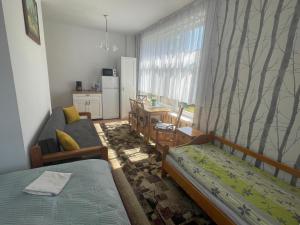 a room with two beds and a table and a kitchen at Domki i pokoje - "KAMERALNY przy promenadzie" ul Wczasowa 2 in Charzykowy