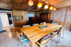 un grande tavolo in legno in una stanza con sedie di Casa Cradd, Spacious Chalet in Nature a Trin