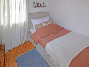 ein kleines Bett in einem Zimmer mit Fenster in der Unterkunft Holiday home LAHOLM XIV in Laholm