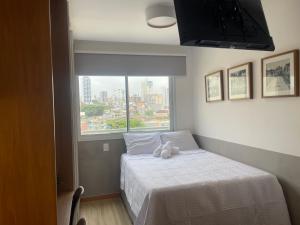 um quarto com uma cama com um bicho de peluche em Noamar Pituba em Salvador