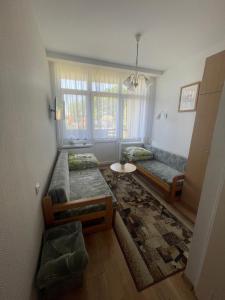 a living room with two beds and a table at Domki i pokoje - "KAMERALNY przy promenadzie" ul Wczasowa 2 in Charzykowy