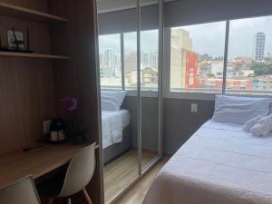 una camera con un letto bianco e una finestra di Noamar Pituba a Salvador