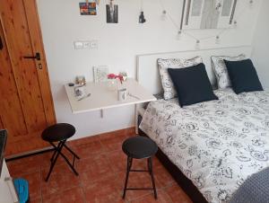 ein Schlafzimmer mit einem Bett mit einem Tisch und 2 Stühlen in der Unterkunft Casa Breizh in Monserrat