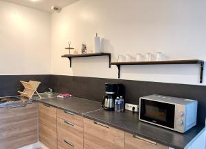 a kitchen with a microwave on top of a counter at Le Balinais - Centre-ville in Melun