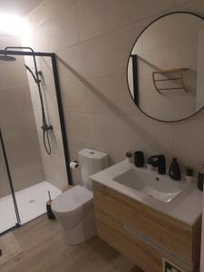 La salle de bains est pourvue de toilettes, d'un lavabo et d'un miroir. dans l'établissement Casinha de Santo Amaro, à Ourém