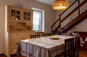 a dining room with a table and a staircase at Sunset House - Casa al Tramonto in Selva di Progno