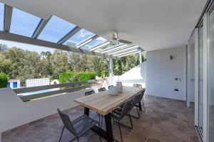 a dining room with a wooden table and chairs at Luxury 5-Bedroom Townhouse in Puente Romano in Marbella